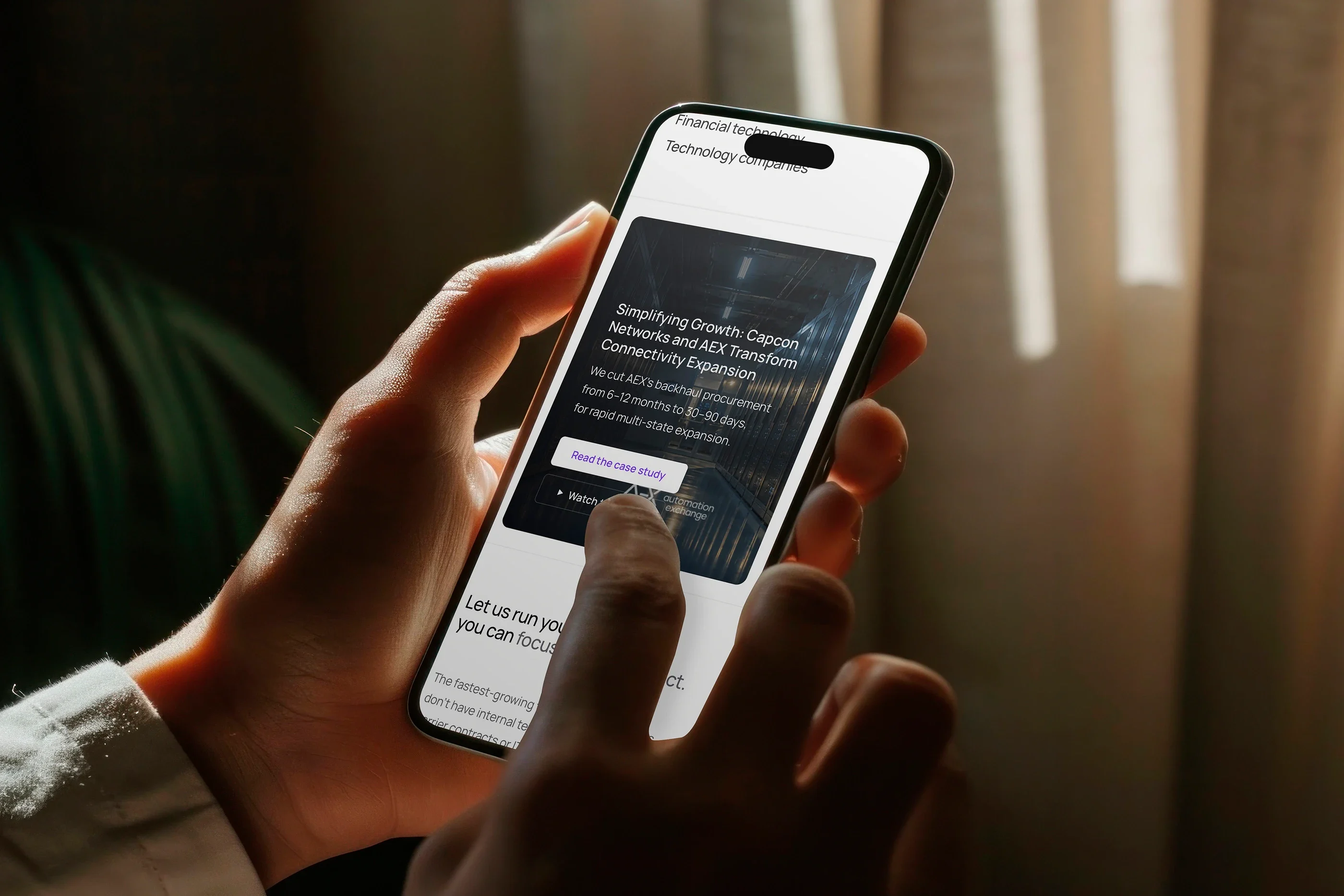 A customer story on the web-centric enterprise page, on a phone in warm light