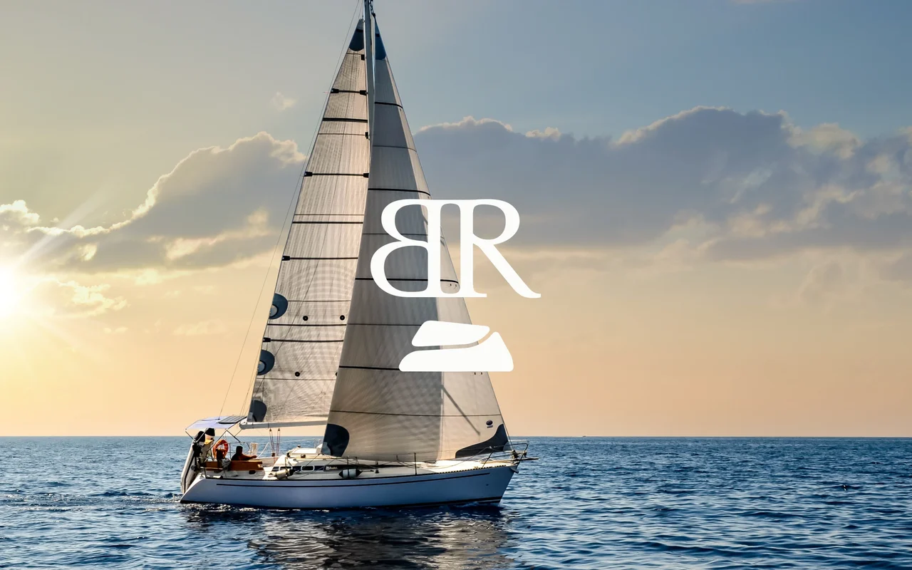 A sailing boat at sunset with the Bedrock monogram