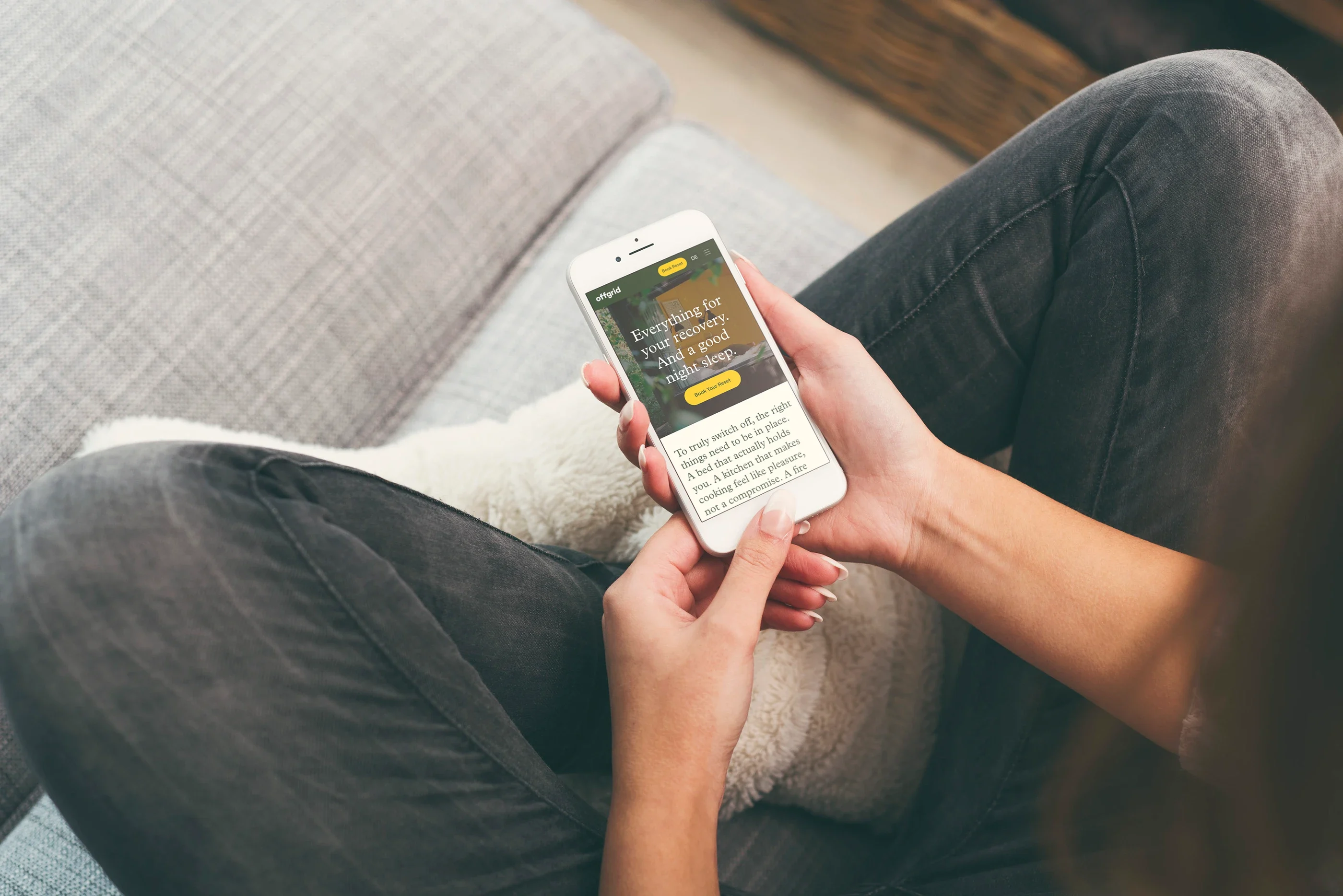 The cabins page, 'Everything for your recovery', on a phone held in someone's lap