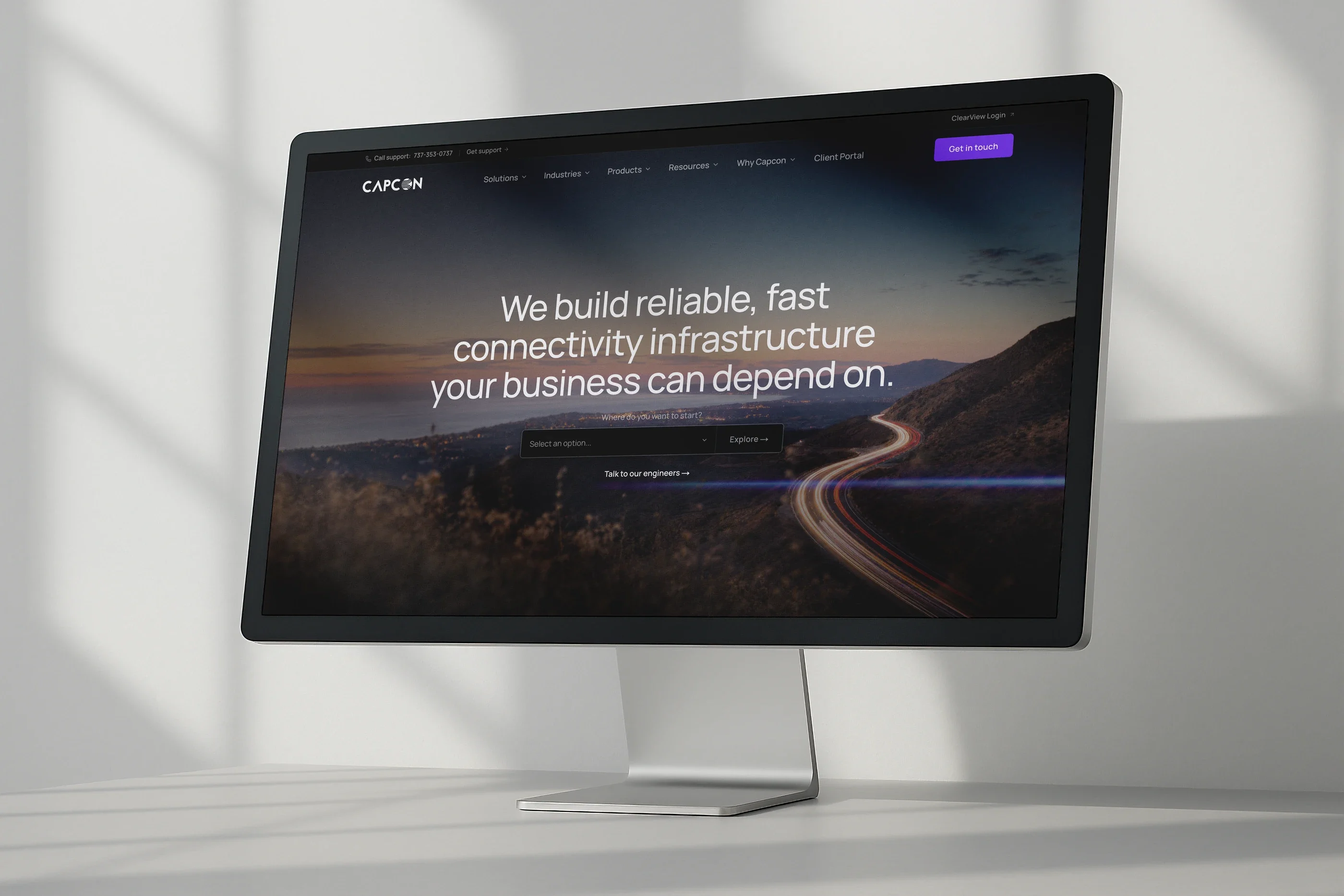 The Capcon home page on a desktop monitor: 'We build reliable, fast connectivity infrastructure your business can depend on.'