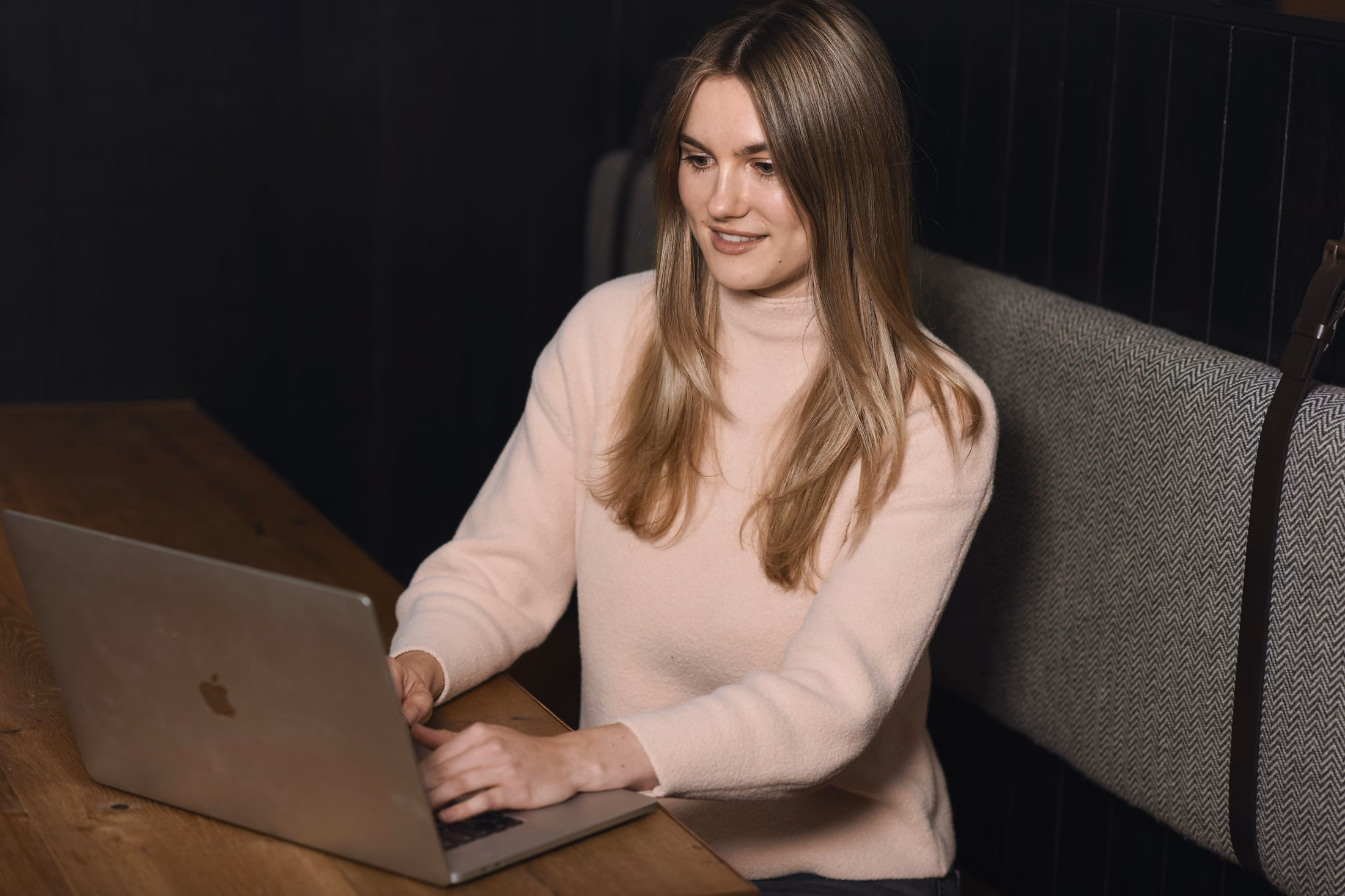 Amelie Morweiser working on her laptop at a wooden table
